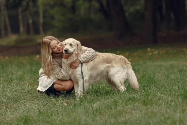 Frau geht mit Hund im Herbstwald spazieren — Stockfoto