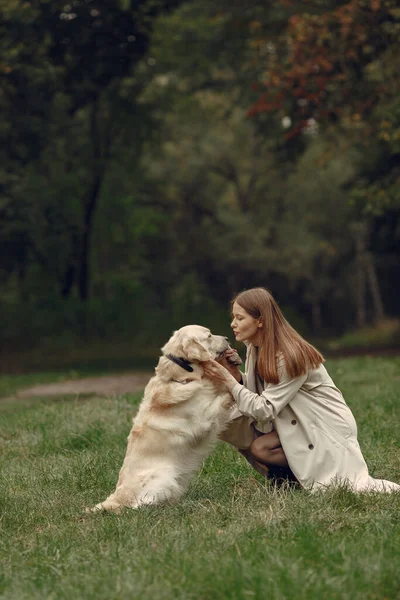 Женщина гуляет в осеннем лесу с собакой — стоковое фото