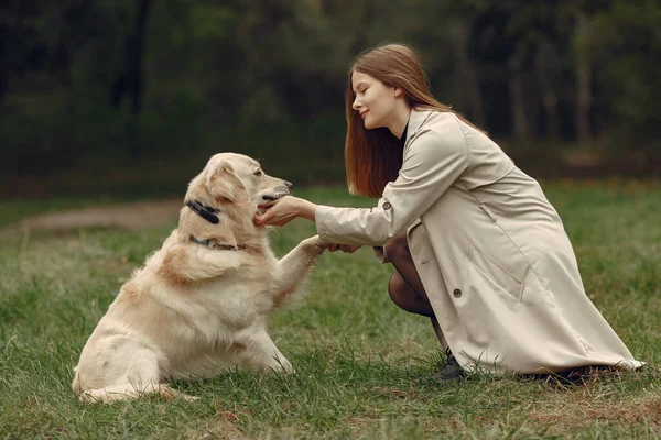 Kvinna vandrar i höstskogen med hund — Stockfoto