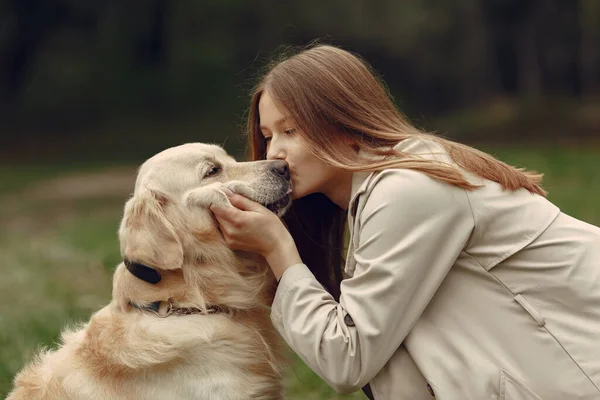 Kvinna vandrar i höstskogen med hund — Stockfoto