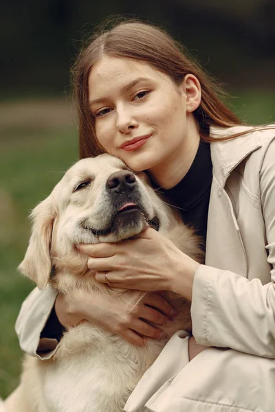 Žena chodí v podzimním lese se psem — Stock fotografie