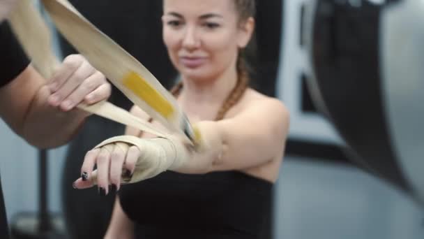 Männlicher Trainer hilft Athletin, vor dem Boxen die Hände zu wickeln — Stockvideo