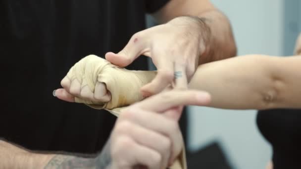 男子训练员在拳击前帮助女子运动员包扎双手 — 图库视频影像