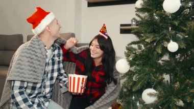 En iyi arkadaşlar yeni yıl arifesinde evde oturup patlamış mısır yiyorlar.