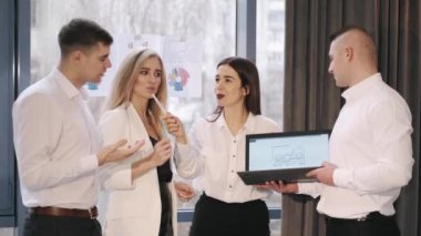 Grup og meslektaşları sohbet ediyorlar ve dizüstü bilgisayardaki verilere bakıyorlar