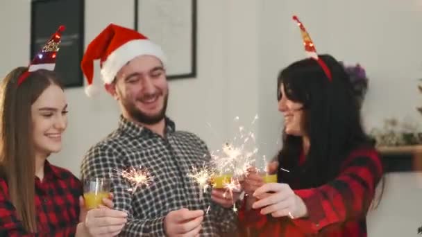 Ungdomar i festliga hattar som håller tomtebloss och firar nyår — Stockvideo