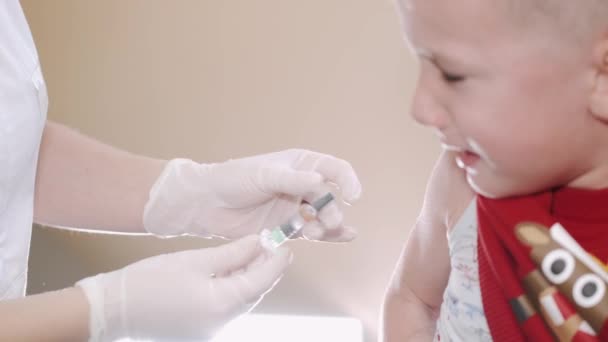 Médico pediatra fazendo vacinação de um menino assustado — Vídeo de Stock