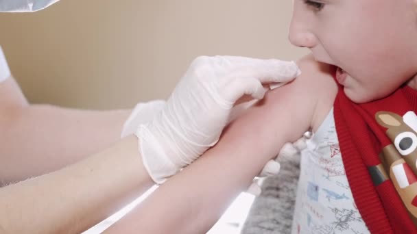 Pediatrician doctor doing vaccination of a little scared boy — Stock Video