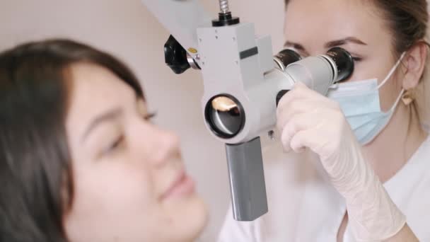 Dokter onderzoekt het oor van een jonge vrouw in de kliniek — Stockvideo