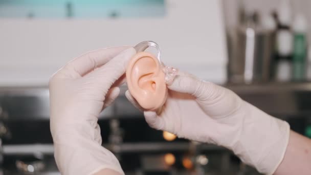 Médico mostrando aparelho auditivo para paciente do sexo feminino — Vídeo de Stock