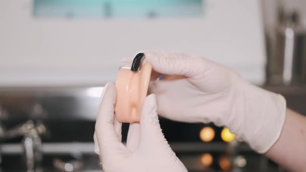 Лікар, що показує слуховий апарат пацієнтці — стокове відео
