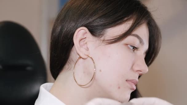 Jovem mulher com um aparelho auditivo BTE colocado em seu ouvido — Vídeo de Stock