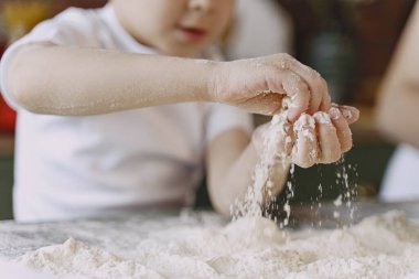 Küçük çocuk kurabiye için hamur pişirir.