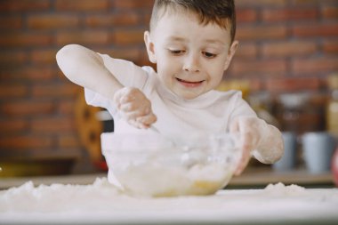 Küçük çocuk kurabiye için hamur pişirir.