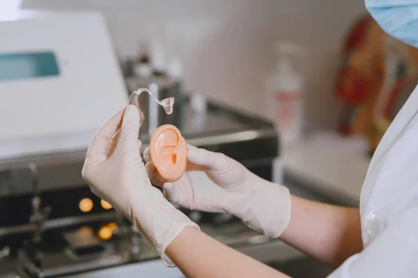 Doctor selects a hearing aid for patient