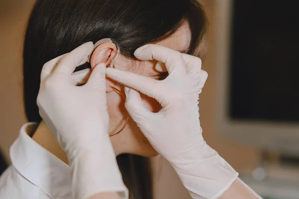 Lekarz wybiera aparat słuchowy dla pacjenta — Zdjęcie stockowe