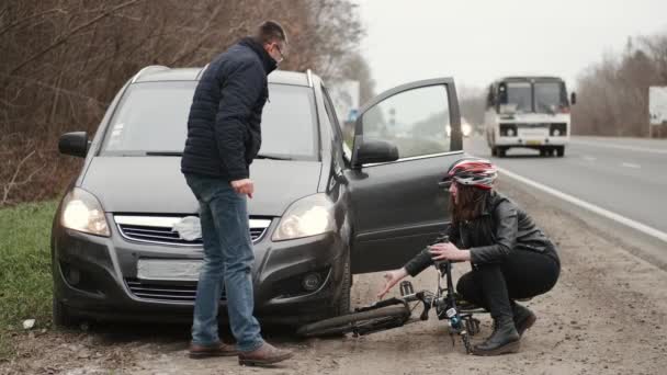 Hombre y mujer discutiendo entre sí después de accidente de bicicleta de coche — Vídeo de stock