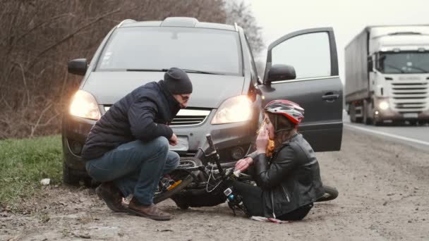 Mężczyzna kierowca próbuje pomóc rowerzysta w wypadku samochodowym — Wideo stockowe