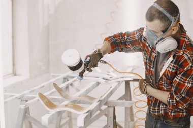 Marangoz boya odasında odun püskürtüyor.