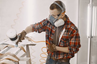 Marangoz boya odasında odun püskürtüyor.