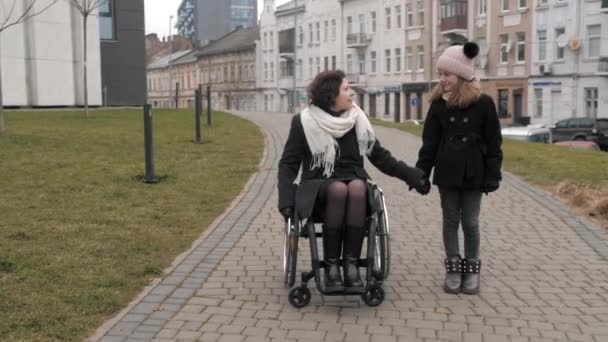 도시에서 장애가 있는 어머니와 함께 걷고 있는 어린 딸 — 비디오