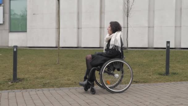 Skolflicka närmar sig sin handikappade mor på trottoaren i en stad — Stockvideo