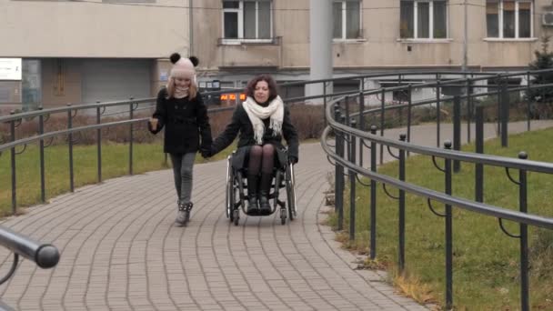 Lille datter går med sin handicappede mor i en by – Stock-video