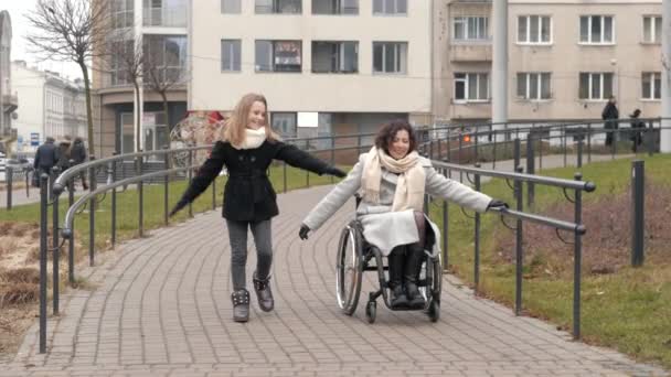 Vrouw in rolstoel hebben plezier met dochter buiten — Stockvideo