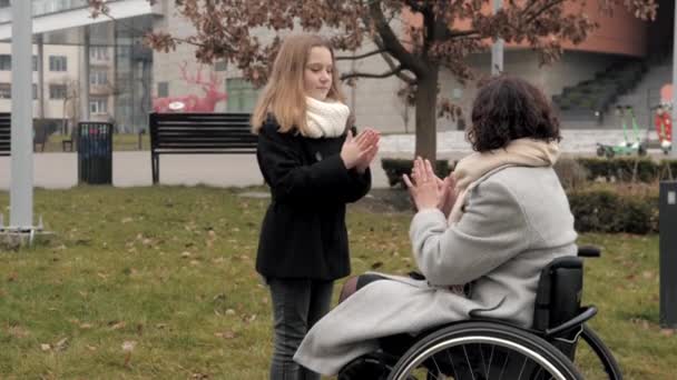 Vrouw in rolstoel hebben plezier met dochter buiten — Stockvideo