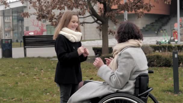 Vrouw in rolstoel hebben plezier met dochter buiten — Stockvideo