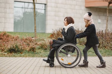 Anne ve kızı tekerlekli sandalyede.