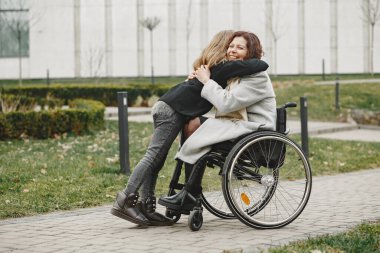 Anne ve kızı tekerlekli sandalyede.