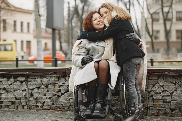 Mãe em uma cadeira de rodas com sua filha — Fotografia de Stock