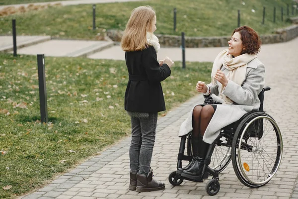 Mãe em uma cadeira de rodas com sua filha — Fotografia de Stock