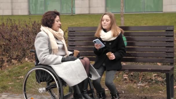 Écolière avec sa mère handicapée buvant du thé dehors — Video