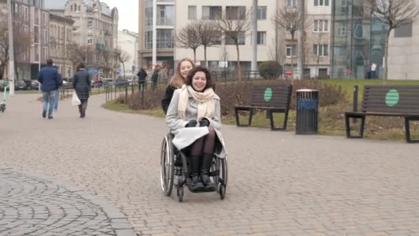 Hijita caminando con su madre discapacitada en una ciudad — Vídeos de Stock