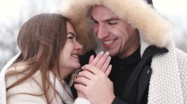 Kareli kumaşa sarılı sevgili çift kışın dışarıda oturuyor.