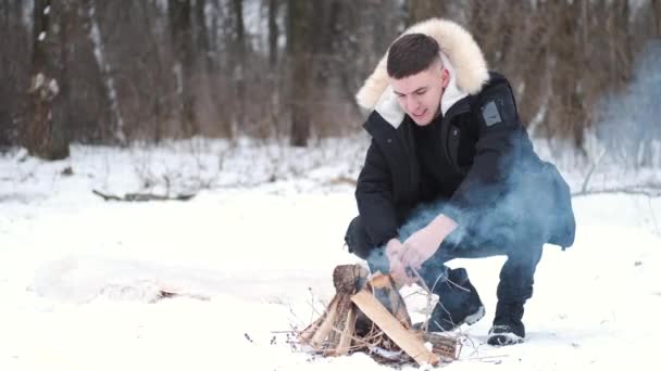 Mujer joven haciendo un fuego para barbacoa en el bosque en invierno — Vídeos de Stock