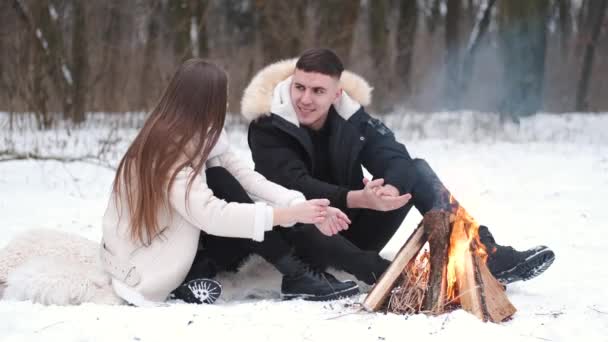 Charmant couple est assis à côté du feu de camp et profiter de leur amour — Video