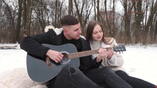 Preciosa pareja está sentada junto a la fogata y disfrutando de su amor — Vídeos de Stock