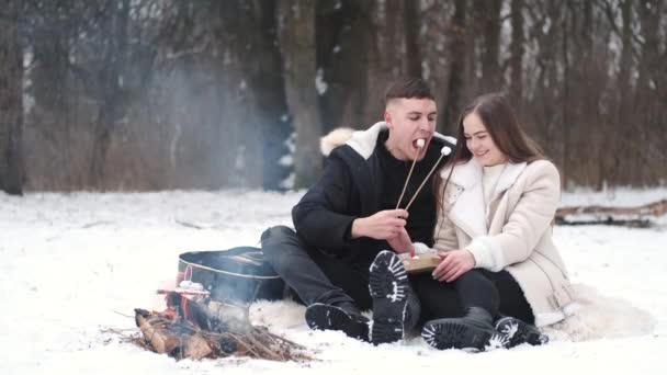 Härligt par sitter bredvid lägerelden och njuter av sin kärlek — Stockvideo