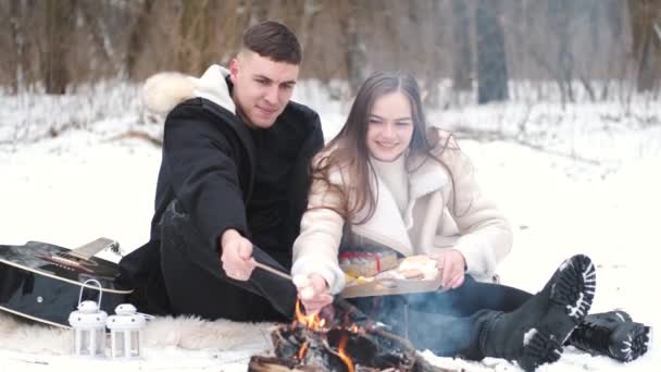 Preciosa pareja está sentada junto a la fogata y disfrutando de su amor — Vídeos de Stock