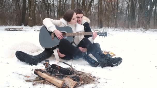 Encantador casal está sentado ao lado da fogueira e desfrutar de seu amor — Vídeo de Stock