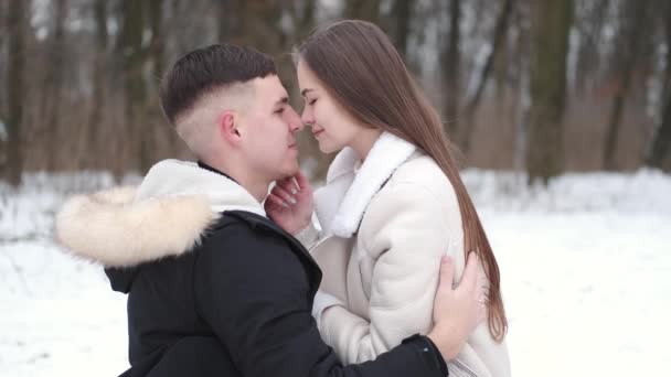 Pareja amorosa envuelta en cuadros sentados fuera en invierno — Vídeos de Stock