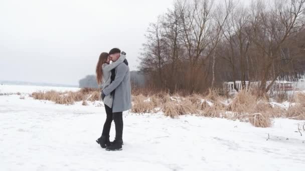 Boldog pár sétál az erdő közelében a befagyott tavon — Stock videók