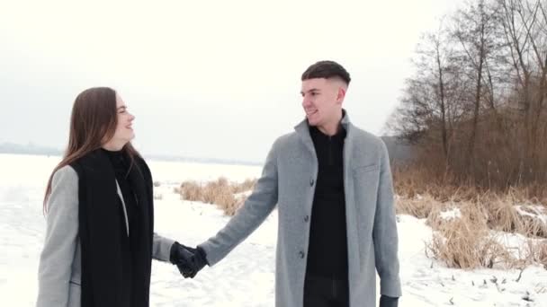 Pasangan bahagia berjalan di dekat hutan di danau beku — Stok Video