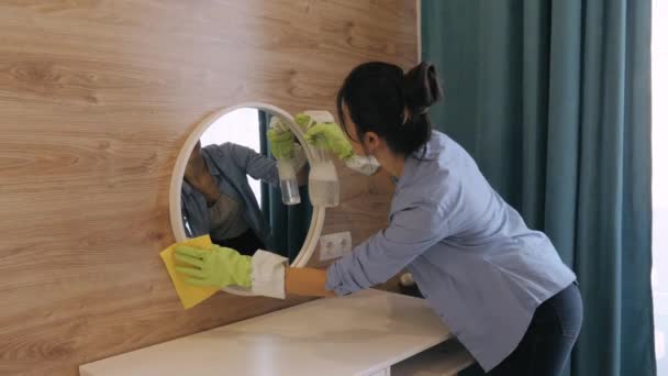 Młoda kobieta z serwisu sprzątania wycierania lustra w domu — Wideo stockowe
