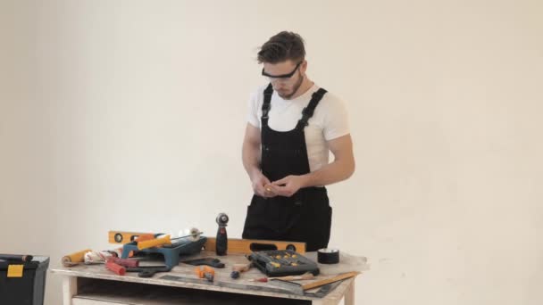 Joven en equipo especial preparando herramientas para la reparación del hogar — Vídeos de Stock