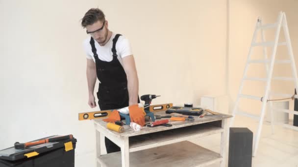Joven en equipo especial preparando herramientas para la reparación del hogar — Vídeo de stock