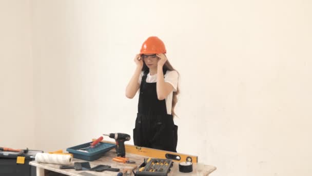 건축 작업복을 입고 일하기 전에 도구를 점검하는 여자 — 비디오